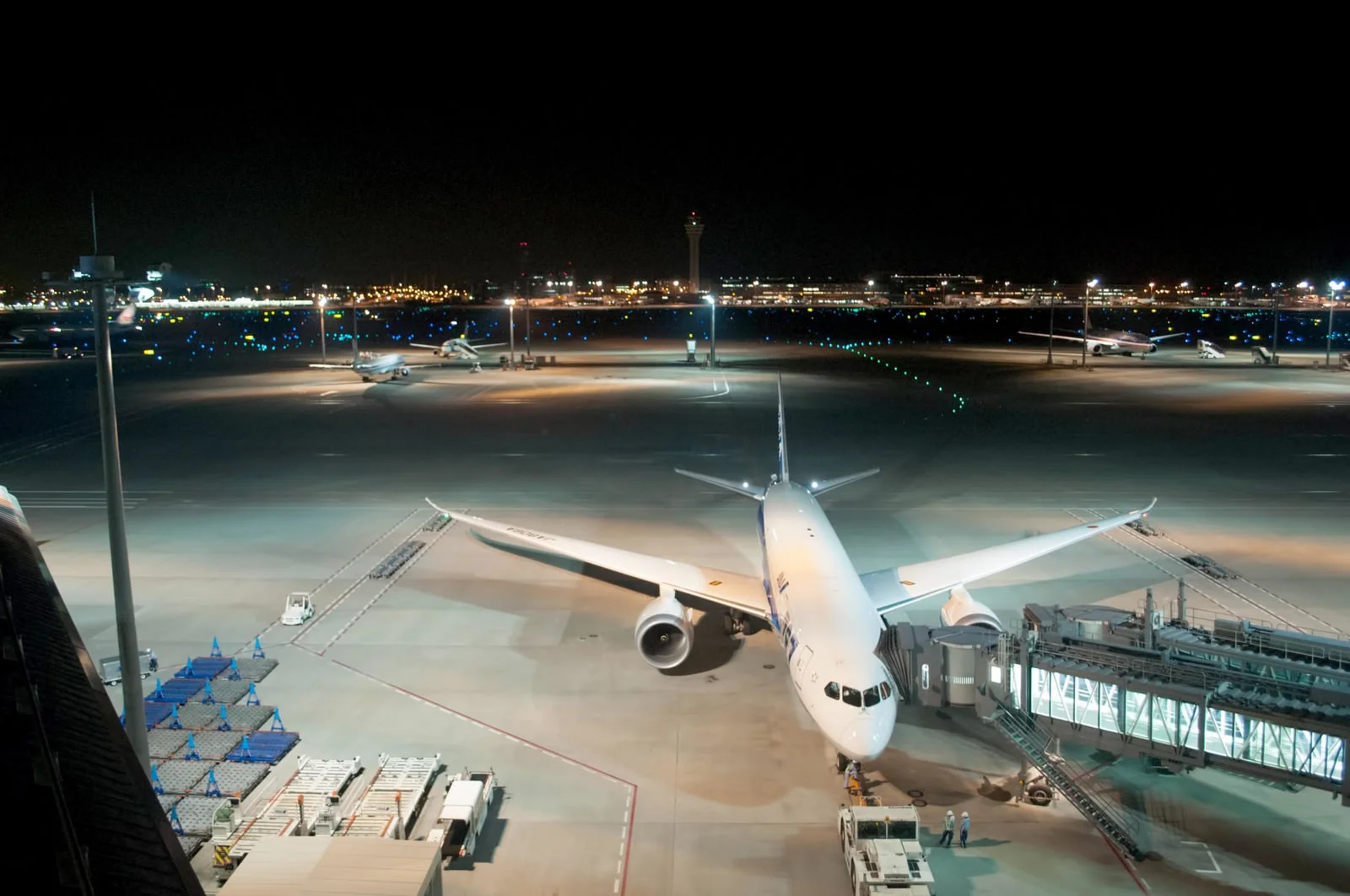 alt="夜間の空港エプロンに駐機する旅客機。世界的な旅客需要回復と航空業界の活況を象徴する風景"