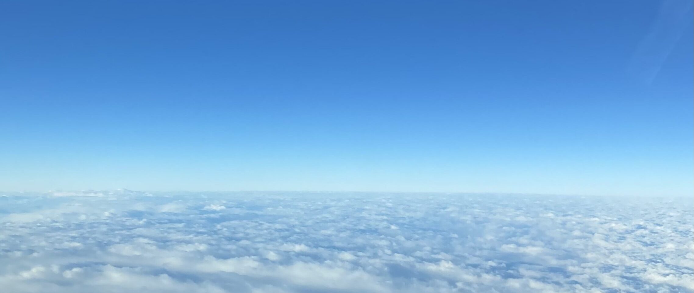 航空業界全体を俯瞰する象徴としての上空から見た雲海と空の風景